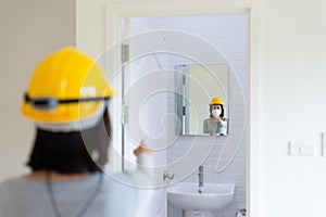 Professional woman home Inspector surveyor wearing vests and hard hat at new house property