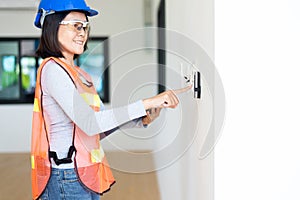 Professional woman home Inspector surveyor wearing vests and hard hat at new house property