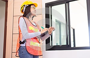 Professional woman home Inspector surveyor wearing vests and hard hat at new property