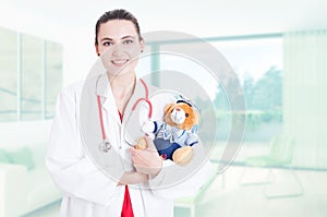 Professional woman medic holding teddy bear