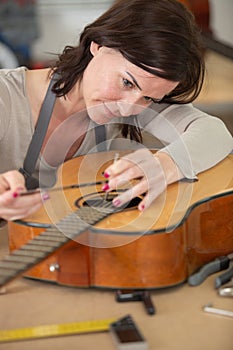 professional woman repairing guitar strings