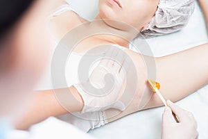 Professional woman at spa doing epilation armpits using sugar - sugaring