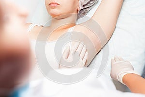 Professional woman at spa doing epilation armpits using sugar, sugaring