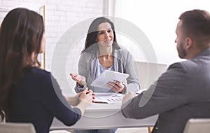 Professional woman talking to young couple at personal meeting