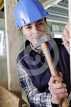 Professional woman using hammer and nail