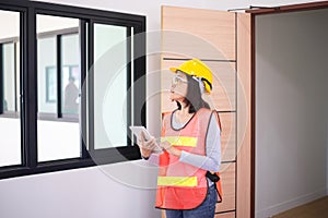 Professional women home Inspector surveyor wearing vests and hard hat at new property