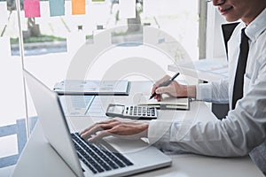 Professional at work, businessman working and analyzing on laptop with calculate statistics of financial document data graph for