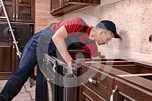 Professional worker assembling oven. Installation of kitchen furniture photo