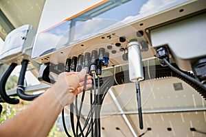 Professional worker connecting wires to solar inverter.