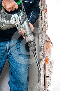 Professional worker handling an jackhammer and drilling