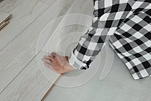 Professional worker installing new laminate flooring, closeup