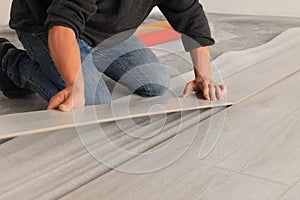 Professional worker installing new laminate flooring, closeup