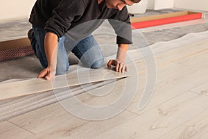 Professional worker installing new laminate flooring, closeup