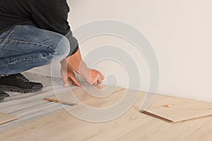 Professional worker installing new laminate flooring, closeup