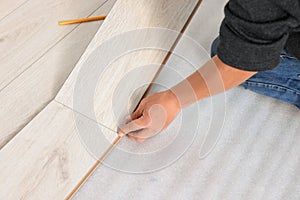 Professional worker installing new laminate flooring, closeup