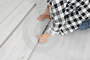 Professional worker installing new laminate flooring, closeup