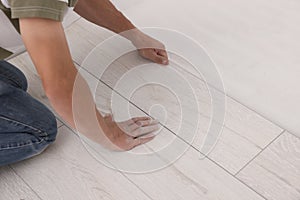 Professional worker installing new laminate flooring, closeup