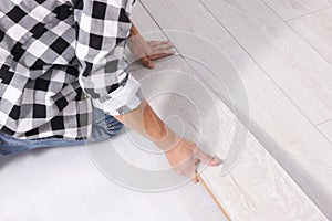Professional worker installing new laminate flooring, closeup