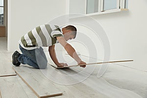 Professional worker installing new laminate flooring indoors