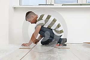 Professional worker installing new laminate flooring indoors