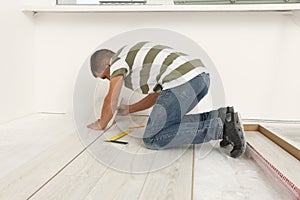 Professional worker installing new laminate flooring indoors