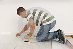 Professional worker installing new laminate flooring indoors