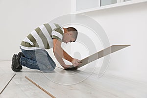 Professional worker installing new laminate flooring indoors