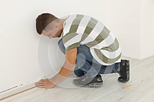 Professional worker installing new laminate flooring indoors