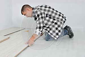 Professional worker installing new laminate flooring indoors