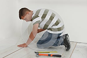 Professional worker installing new laminate flooring indoors