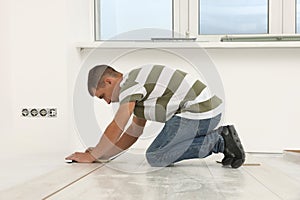 Professional worker installing new laminate flooring indoors
