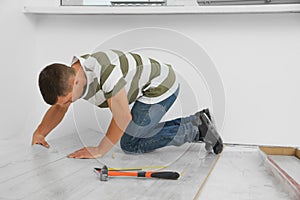 Professional worker installing new laminate flooring indoors