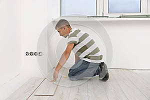 Professional worker installing new laminate flooring indoors