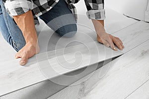 Professional worker installing new laminate flooring indoors, closeup