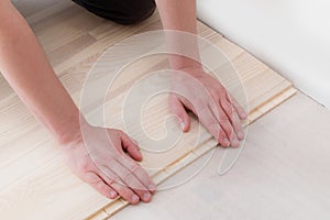 Professional worker installing new parquet flooring indoors, closeup