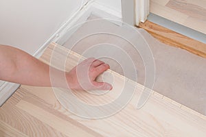 Professional worker installing new parquet flooring indoors, closeup