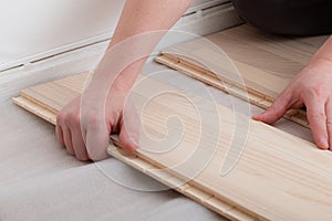 Professional worker installing new parquet flooring indoors, closeup