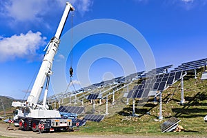 Professional worker installing solar panels on the gray metal construction. photo