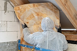 Professional worker in overalls working with rockwool insulation material