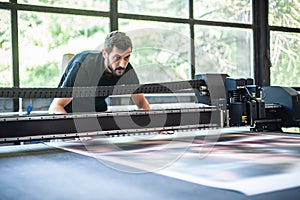 Professional worker printmaker technician operator works in modern printing plant