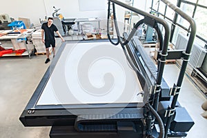 Professional worker printmaker technician operator works in modern printing plant