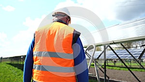 Professional worker at solar farm maintains the panels.