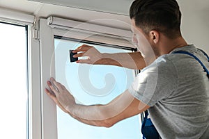 Professional worker tinting window with foil