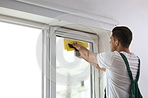Professional worker tinting window with foil. Space for text
