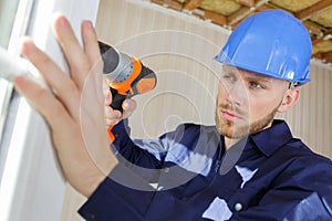 professional worker using drill on pvc window
