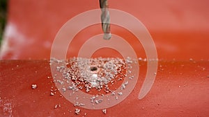 The professional worker using drill to make a hole in a red roof tile, construction concept. Stock footage. Industrial