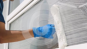 A professional worker washes windows with special products. Cleaning service