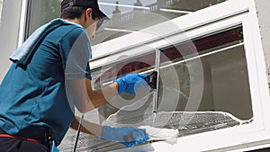 A professional worker washes windows with special products. Cleaning service