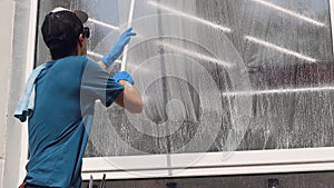 A professional worker washes windows with special products. Cleaning service