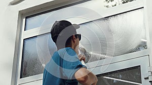 A professional worker washes windows with special products. Cleaning service